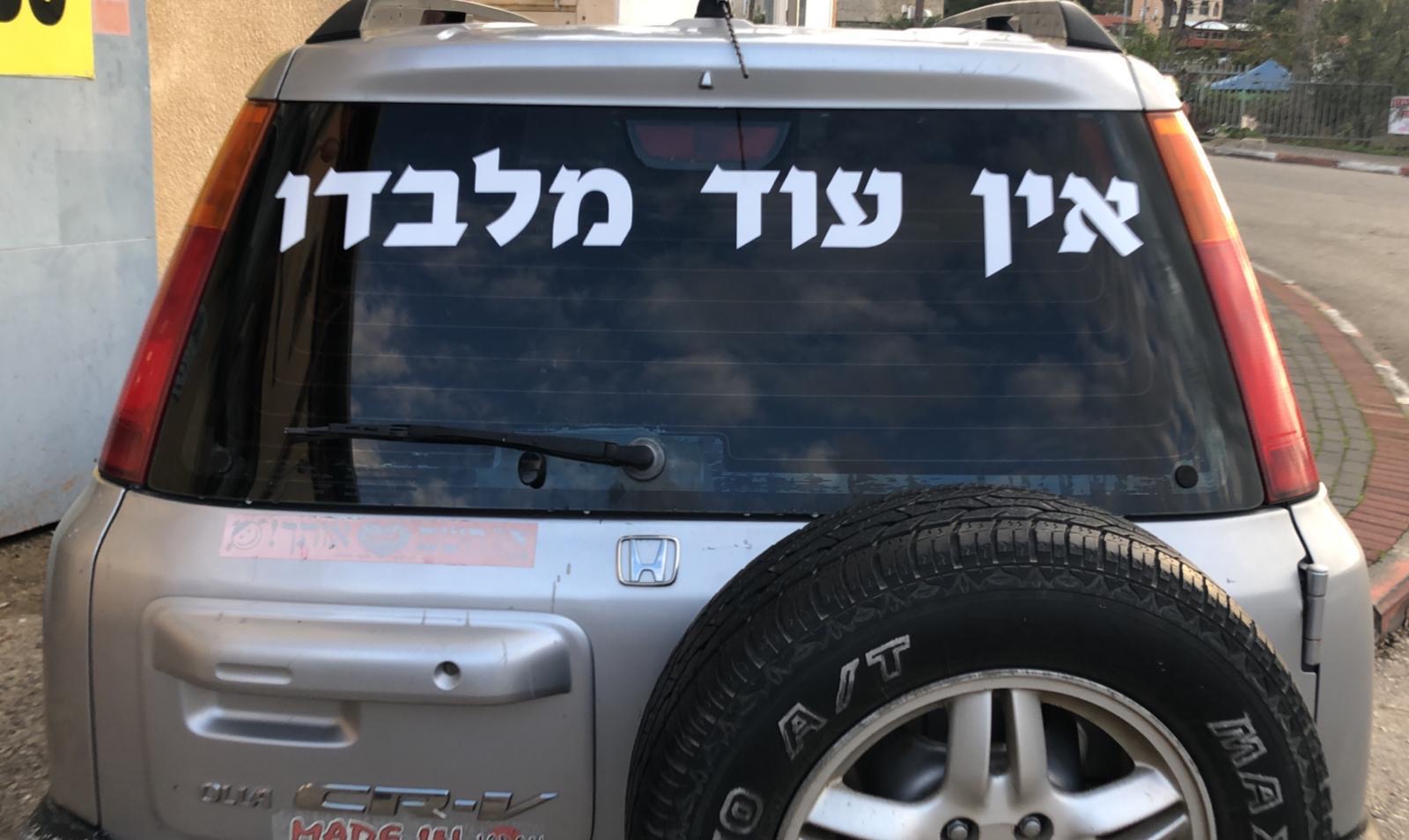 מדבקת אותיות לבנות על רכב